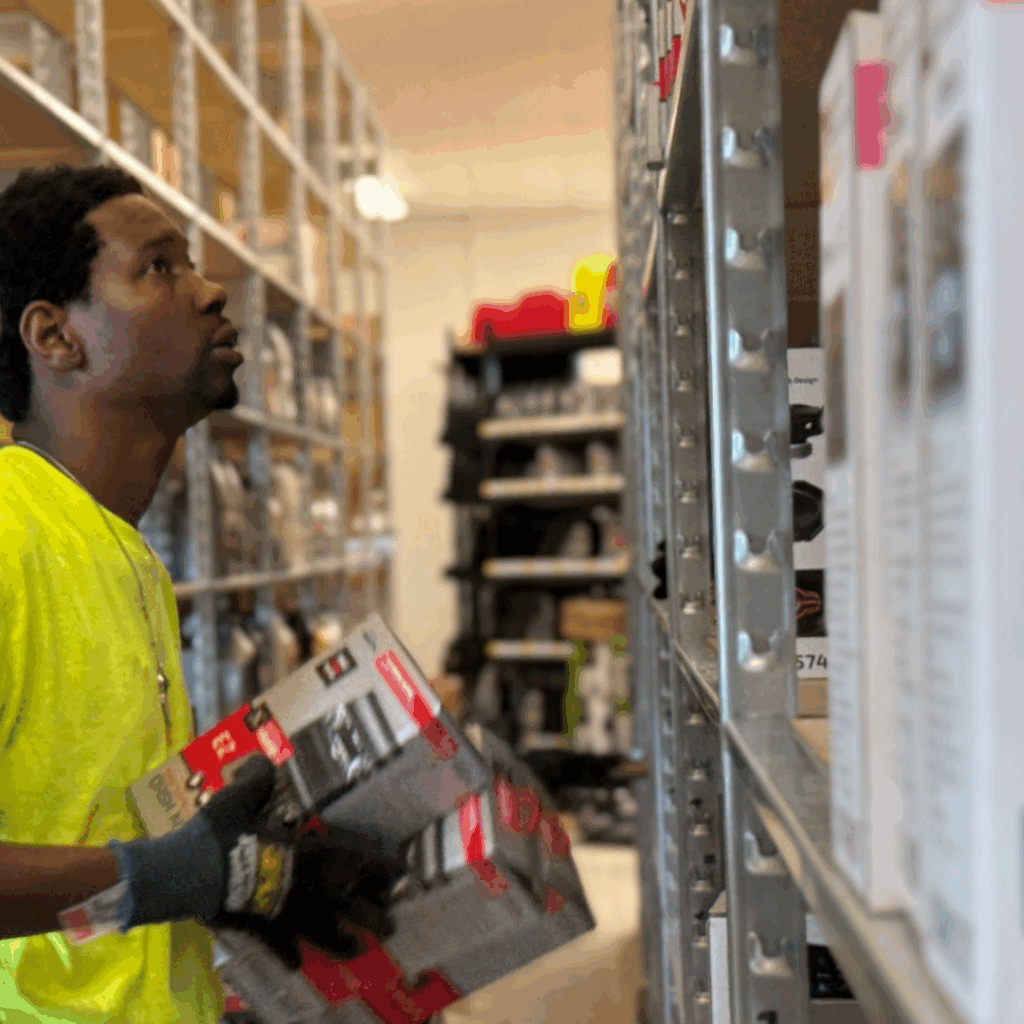 Crew member organizing fixtures and preparing the sales floor during post-holiday retail assessments